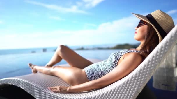 beelden van Aziatische vrouw ontspannen in zwembad tijdens de zomer vakantie - Video