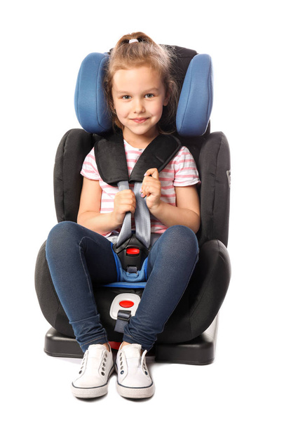 Menina fivela no assento de segurança do carro contra fundo branco
 - Foto, Imagem