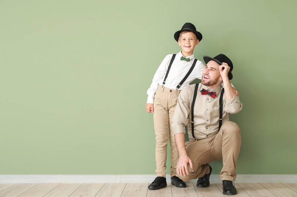 Portrait of fashionable father and son near color wall - Foto, Imagen
