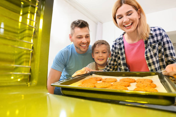 Family taking baking tray with cookies out of oven - Photo, Image