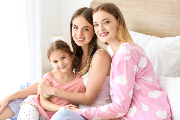 Felice coppia lesbica con piccola figlia in camera da letto
 - Foto, immagini