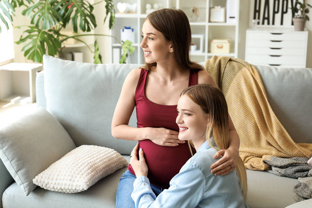 Happy pregnant lesbian couple at home - Fotoğraf, Görsel