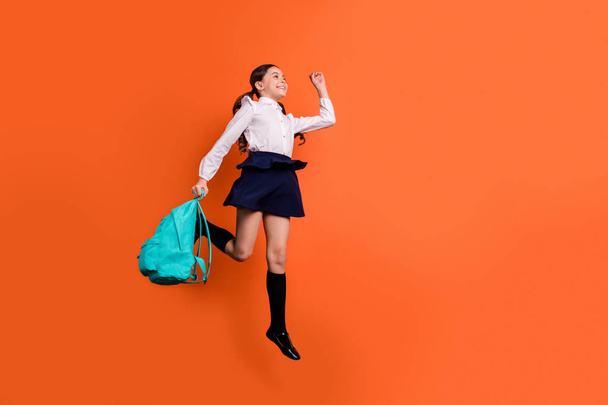 Full length body size view photo of cheerful sweet cute kid lesson classroom rejoice enjoy boots ponytails pigtails long socks white blouse shirt isolated orange background - 写真・画像