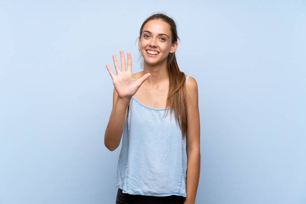 Young woman over isolated blue background counting five with fingers - Φωτογραφία, εικόνα