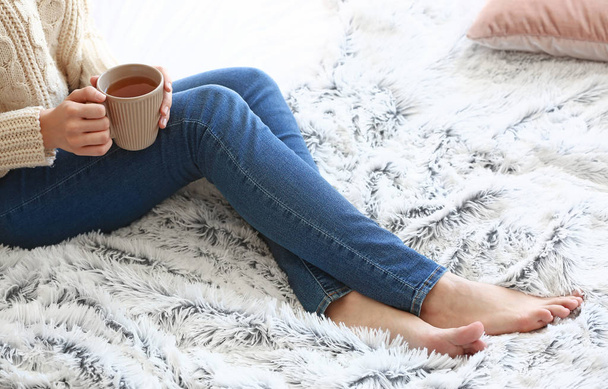 Mujer joven bebiendo té caliente en casa
 - Foto, imagen