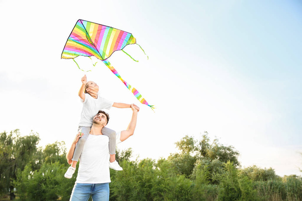 Fiatal férfi kislánya repülő kite szabadban - Fotó, kép