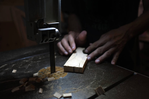 Asztalos építő munka elektromos szúrófűrész és fa. Woodworker vágás egy darab fát   - Fotó, kép
