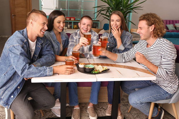 Друзья пьют свежее пиво в пабе
 - Фото, изображение