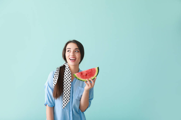 Beautiful young woman with slice of fresh watermelon on color background - Photo, Image