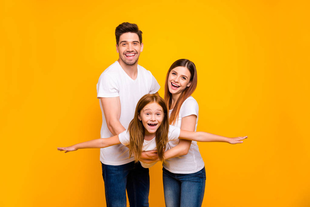 Photo of three family members spending leisure time playing games wear casual outfit isolated yellow background - Photo, image
