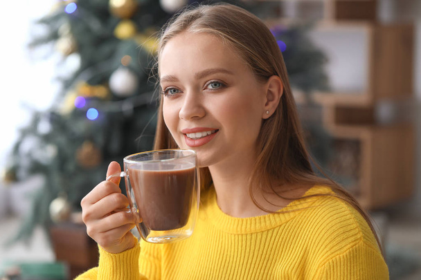 Beautiful woman drinking hot chocolate at home - 写真・画像