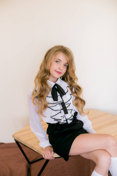 Cute girl with long blond curly hair in school fashion clothes. School fashion in vintage elite style. - Zdjęcie, obraz