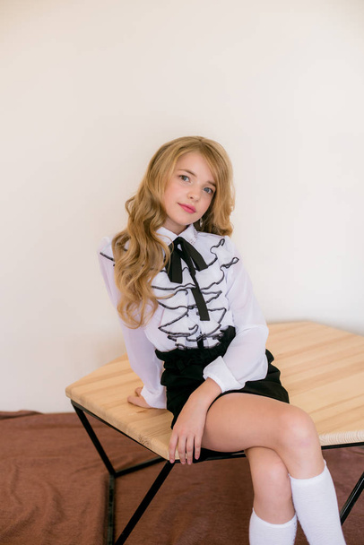 Cute girl with long blond curly hair in school fashion clothes. School fashion in vintage elite style. - Photo, Image
