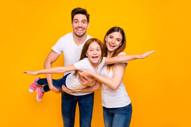 Photo of three family members spending leisure time playing games wear casual outfit isolated yellow background - Fotó, kép