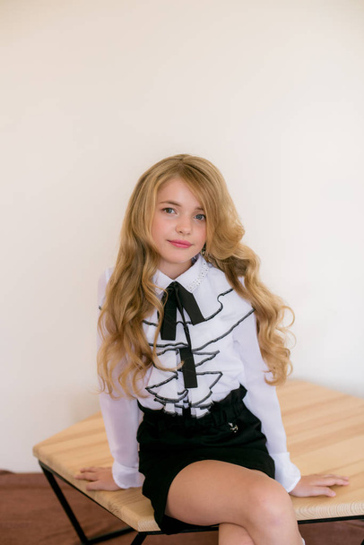 Cute girl with long blond curly hair in school fashion clothes. School fashion in vintage elite style. - Zdjęcie, obraz