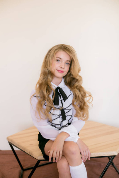 Cute girl with long blond curly hair in school fashion clothes. School fashion in vintage elite style. - Фото, изображение