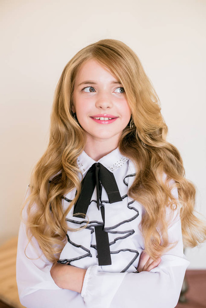 Cute girl with long blond curly hair in school fashion clothes. School fashion in vintage elite style. - Φωτογραφία, εικόνα