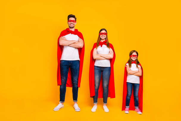 Three family members playing cartoon incredible characters wear superhero cloaks isolated yellow background - Foto, afbeelding