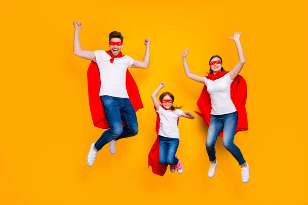 Crazy daddy mommy and foxy daughter jumping high wear cartoon superhero capes isolated yellow background - Фото, изображение