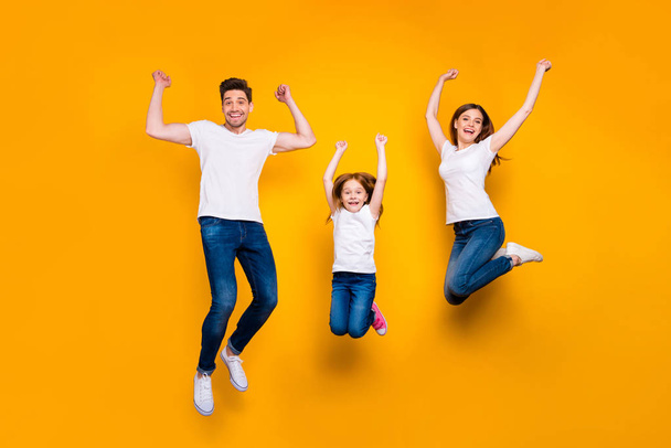 Full length body size view of three nice attractive slim sporty lovely cheerful cheery person having fun rejoicing attainment success accomplishment isolated over bright vivid shine yellow background - 写真・画像