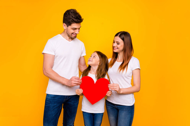 Dad mom and little foxy lady after safe cardiac operation hold paper heart wear casual outfit isolated yellow background - Foto, Bild