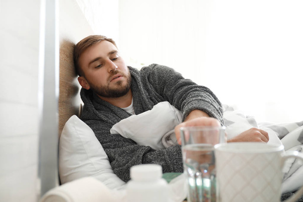 Man ziek met griep liggend in bed - Foto, afbeelding