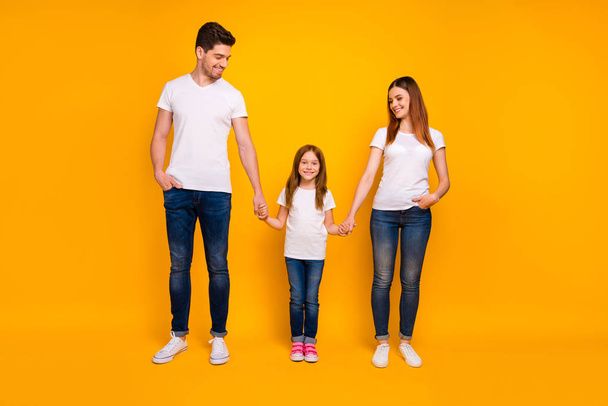 Full length body size view of three nice attractive stylish trendy cheerful cheery friendly person holding hands spending weekend leisure isolated over bright vivid shine yellow background - Foto, Imagem