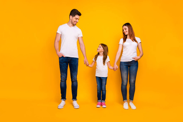 Full length body size view of three nice-looking attractive lovely charming stylish cheerful cheery friendly person holding hands spending weekend life isolated on bright vivid shine yellow background - Foto, imagen