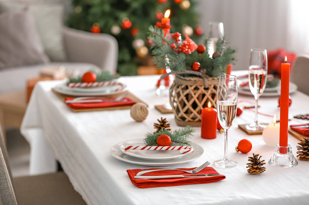 Beautiful table setting with Christmas decorations in living room - 写真・画像