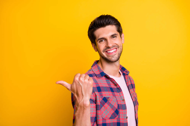 Photo of cheerful enjoying man showing you direction how to get to nearest coffee house while isolated with yellow background - Foto, Bild