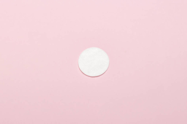 Katoen hygiënische make-up schijf op een roze achtergrond. Concept van make-up en hygiëne. Platte lay, bovenaanzicht - Foto, afbeelding
