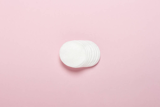 Cotton hygienic discs for makeup on a pink background. Makeup and hygiene concept. Flat lay, top view - Photo, image