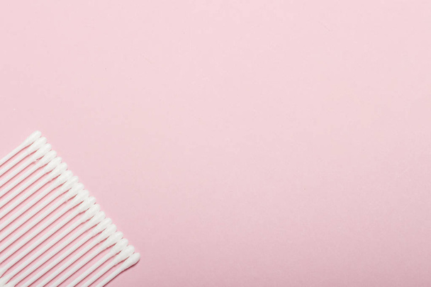 Hygiënische katoenen toppen op een roze achtergrond. Persoonlijke verzorgingsproducten concept. Platte lay, bovenaanzicht - Foto, afbeelding