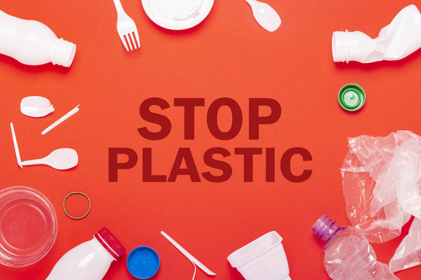 Raccolta rifiuti in plastica su fondo rosso. Concetto fermare rifiuti riciclaggio di plastica. Posa piatta, vista dall'alto
 - Foto, immagini