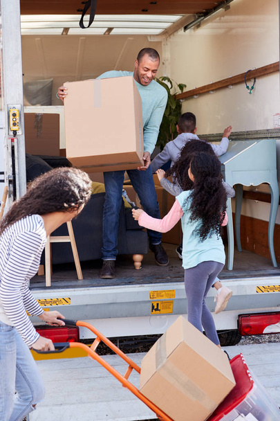 Family Unloading Furniture From Removal Truck Into New Home - Φωτογραφία, εικόνα