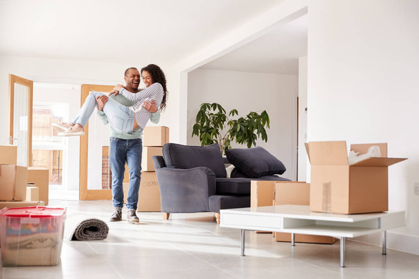Man Carrying Woman Over Threshold Of New Home On Moving Day - Foto, imagen