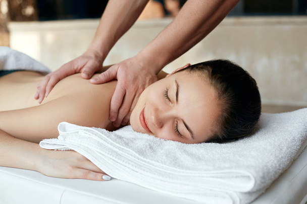 Masseur doing massage on woman body in the spa salon. Beauty treatment concept. Body care. Girl having massage in the spa salon - Фото, зображення