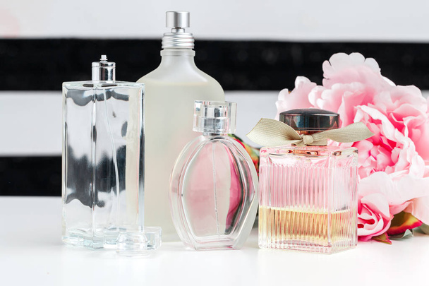 Bottles of perfume with flowers on white background - Foto, afbeelding