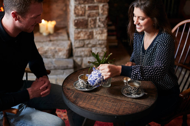 Couple Sitting At Table Drinking Tea In Traditional English Holiday Hotel - 写真・画像