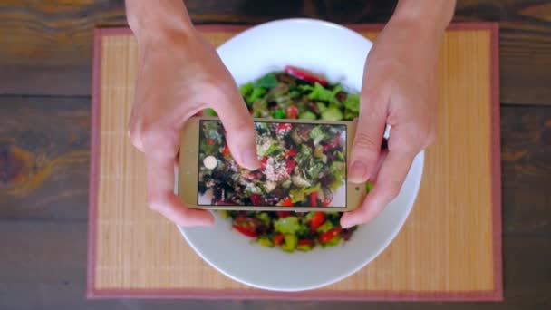 Vrouwelijke handen fotograferen vegetarisch eten per smartphone. - Video