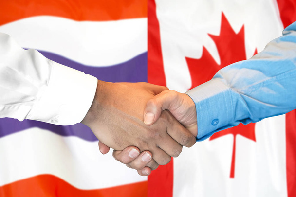 Poignée de main sur fond de drapeau thaïlandais et canadien
. - Photo, image