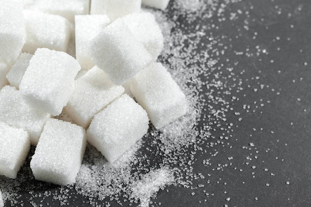 Білі кубики цукру на чорному фоні крупним планом
 - Фото, зображення