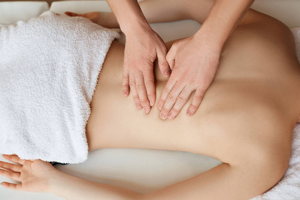 Jeune femme relaxante avec massage des mains au spa de beauté. - Photo, image