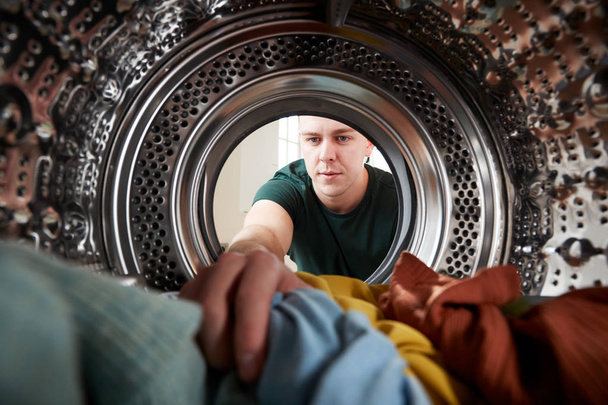 View Looking Out From Inside Washing Machine As Young Man Does Laundry - Foto, immagini