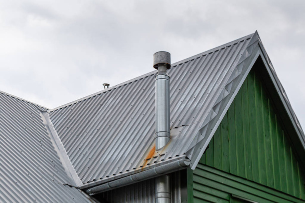 telhado de aço da casa velha com calha e chaminés de ventilação
. - Foto, Imagem