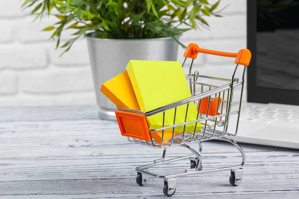 Shopping Online Concept : Mini Shopping Cart and Laptop - Foto, imagen