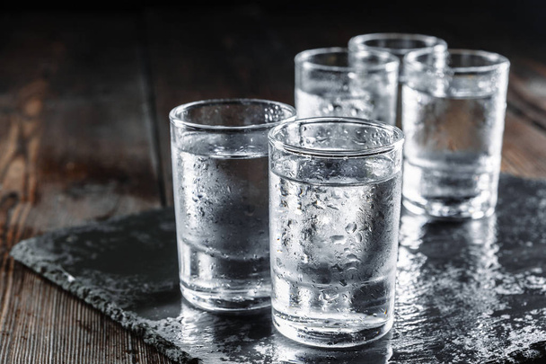 Vodka in shot glasses on rustic wood background - Foto, immagini