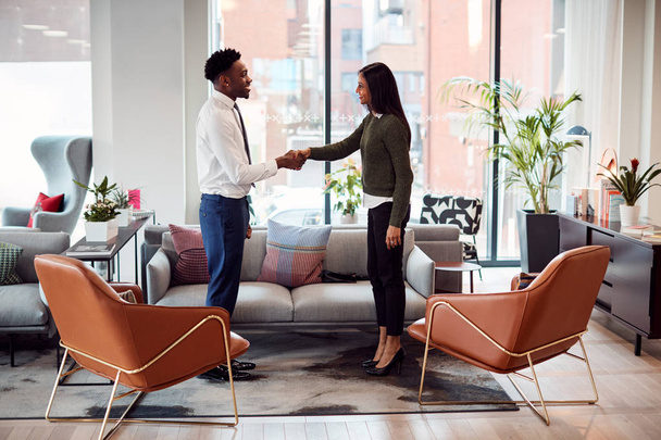 Businesswoman Shaking Hands With Male Interview Candidate In Seating Area Of Modern Office - Foto, afbeelding