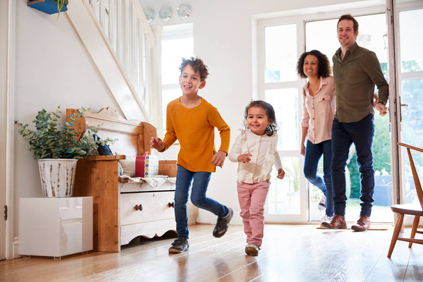 Family Returning Home After Trip Out With Excited Children Running Ahead - Photo, image