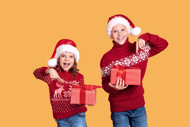 Happy children holding red gift boxes - Valokuva, kuva